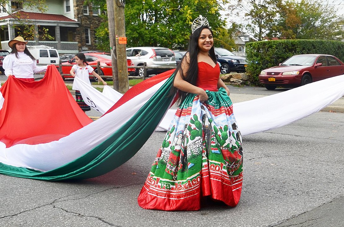 Port Chester beauty Cecelia Chavez wears a gorgeous gown with a Mexican flag train as she processes with the Comitiva Guadelupana Port Chester group. 