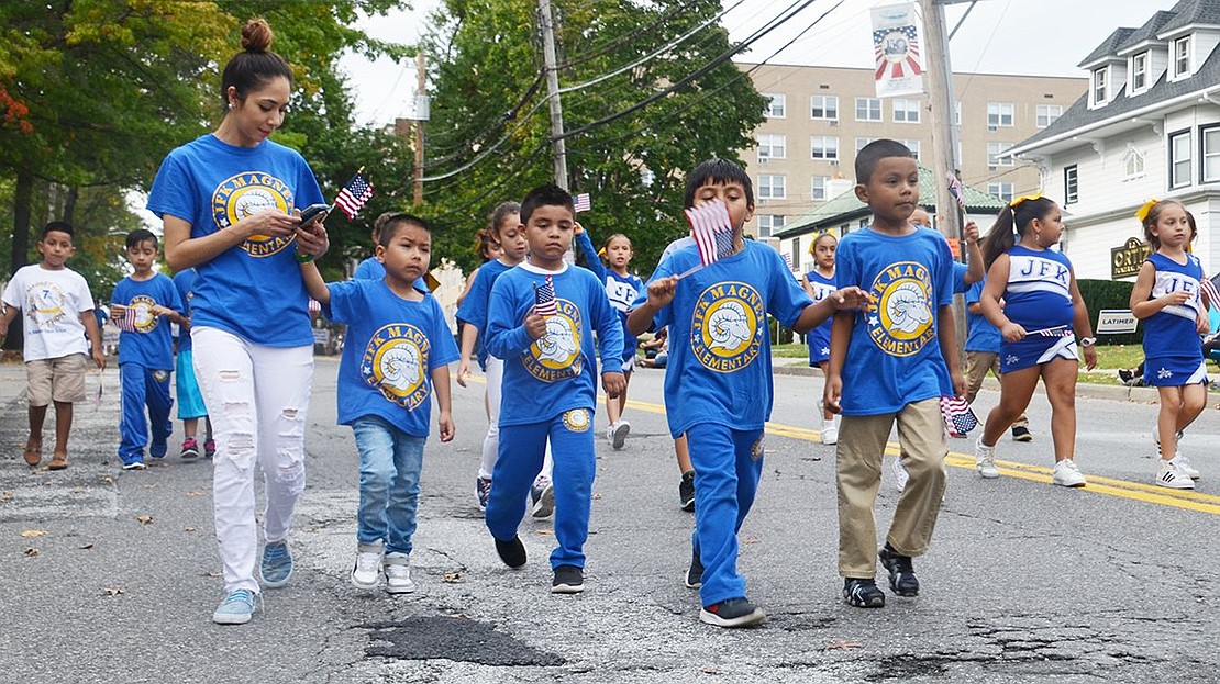 John F. Kennedy Magnet School students fill the street in three long lines. 