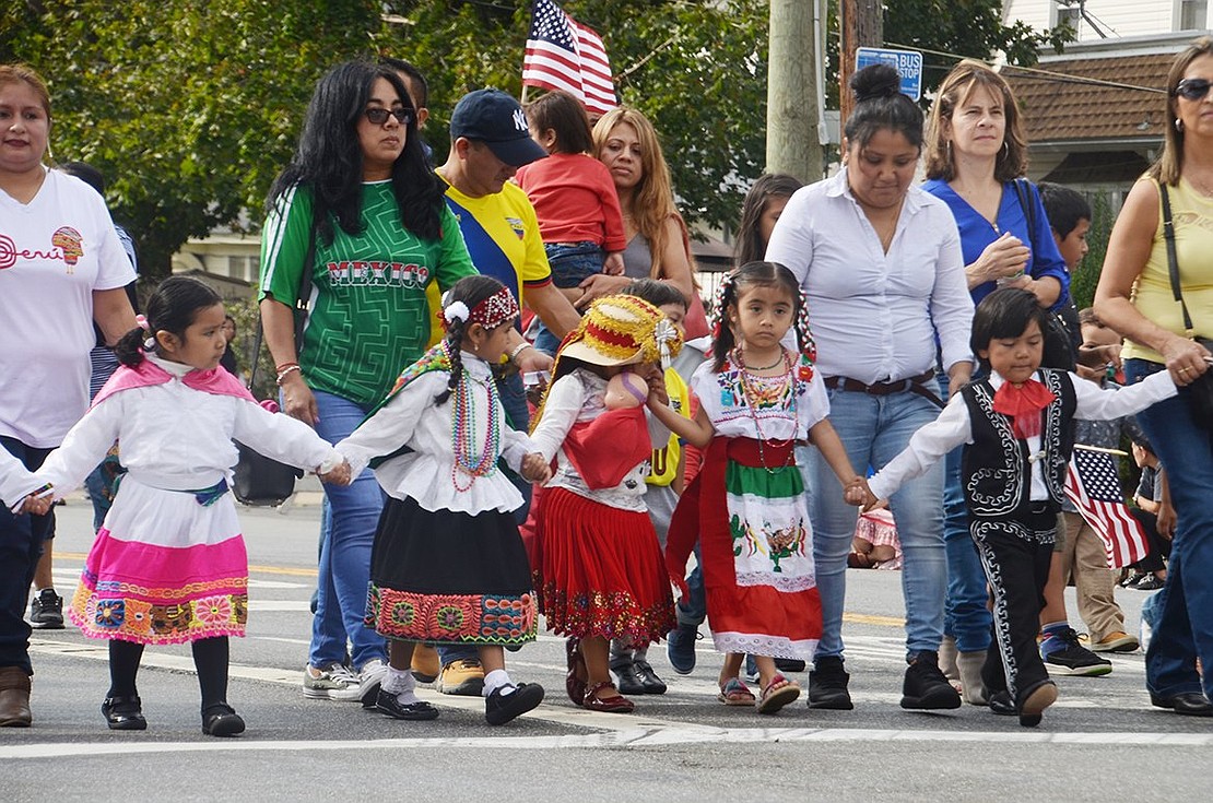 Girls from Port Chester’s Head Start program link hands and don ethnic dresses to display their heritage. 