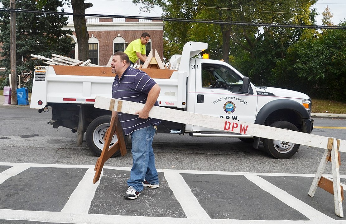 Port Chester Department of Public Works employees Mike Barrella and Moe Arango follow the parade to quickly reopen streets. 