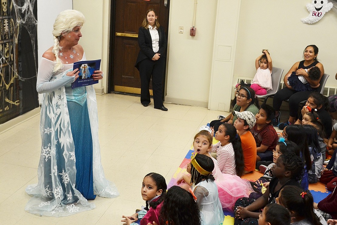 Elsa (children’s librarian Tee Cotter) tells the kids how The Remarkable Renaldo donated two of his books, “Renaldo Joins the Circus,” to the library. 