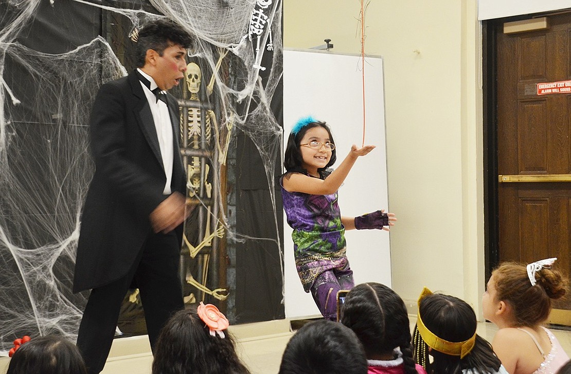 The Remarkable Renaldo holds a balancing contest with one of the audience members.