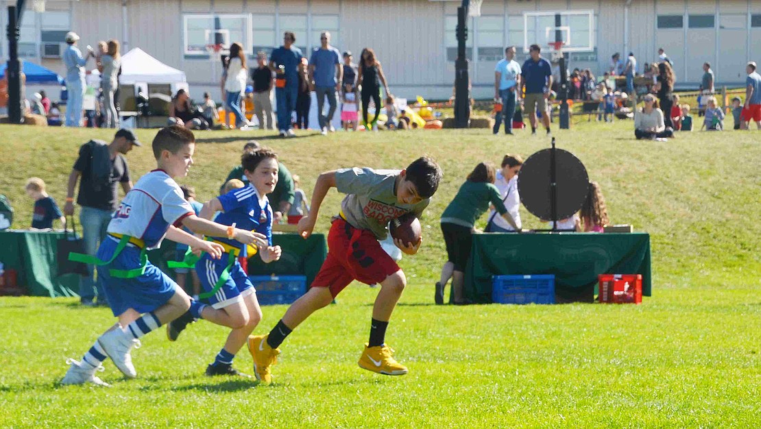 Many of the boys opt to play football instead of perusing the various tables. 