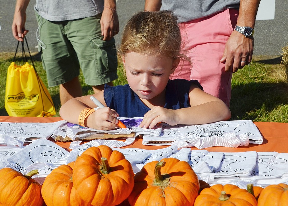 Blind Brook’s Fall Festival was filled with fun things to do, like face painting, coloring, sports and more. Four-year-old Carly Katz of Eagles Bluff takes full advantage of the Saturday, Oct. 21 activities by decorating a Halloween-themed bag. The event was held behind Bruno M. Ponterio Ridge Street School. 