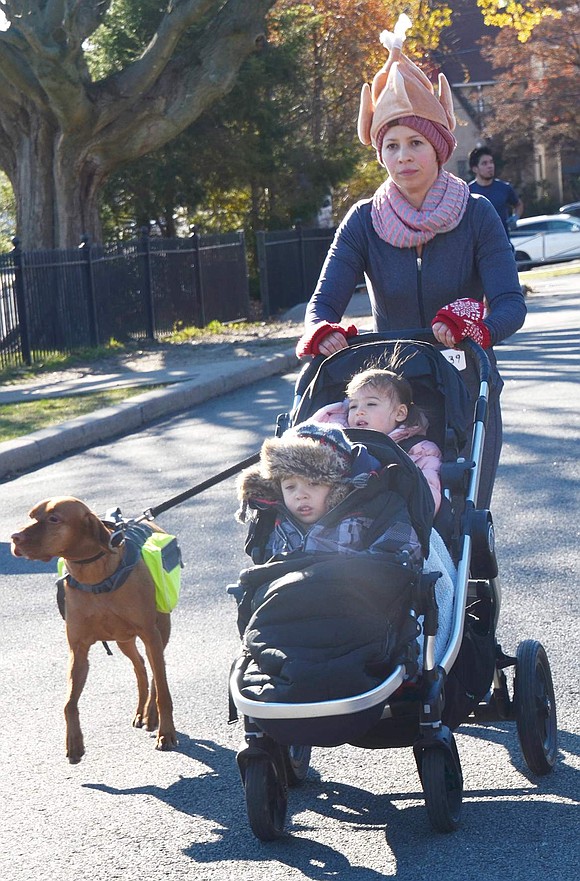 Jessica Ramirez of Rye Brook, wearing a turkey hat, pushes her son Mason, 3½, and daughter Peyton, almost 2, in a stroller in the race and is accompanied by her dog Zeland, a Vizsla. She was among the more than 200 who walked or ran the course and in so doing contributed to the Tamarack Tower Foundation which raises money for the Port Chester public schools.