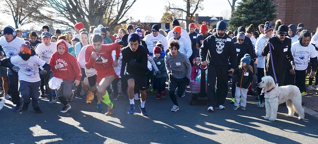 More than 200 walkers and runners take off from the starting line adjacent to the flagpole behind Port Chester High School. Leonard Pietrafesa of Quintard Drive (in front left of middle wearing red) finished the 3.5K race second while Phil Falk, who grew up in Port Chester and now lives in Manhattan, came in first with a time of 16:07.