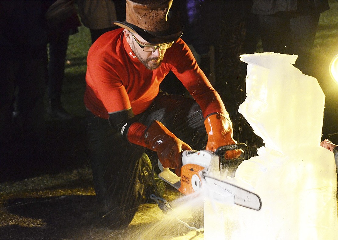 Festival ice carver Eric Wagner carefully maneuvers his chainsaw to create an ice sculpture of Olaf the snowman from Disney’s “Frozen.” 