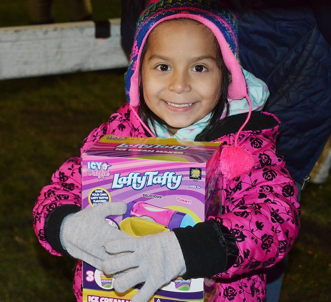 Isabella Diaz, a 5-year-old Port Chester resident, clutches her Laffy Taffy present before she gets on stage to meet Santa. Every child received a present before meeting the Christmas legend during Santa in the Park at Lyon Park on Wednesday, Dec. 6.  