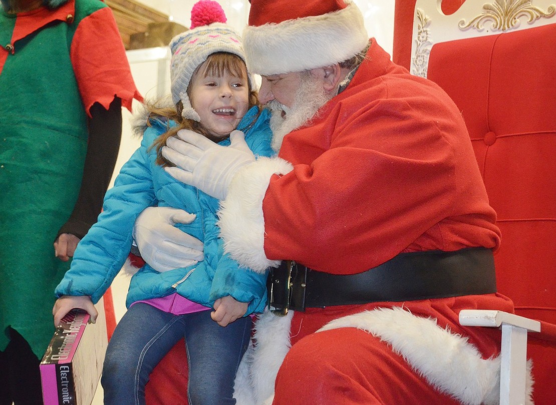 Santa must have said something funny. Greenwich, Conn. 5-year-old Angelina Egan shares a laugh with the jolly North Pole visitor while sitting on his lap. 