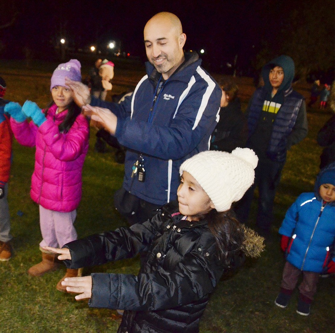 High School Band Director Mike Miceli hands the music over to 6-year-old Jamie Gonzalez (right) and 9-year-old Jamie-Lynn Lopez, as he teaches them how to conduct the brass ensemble.    