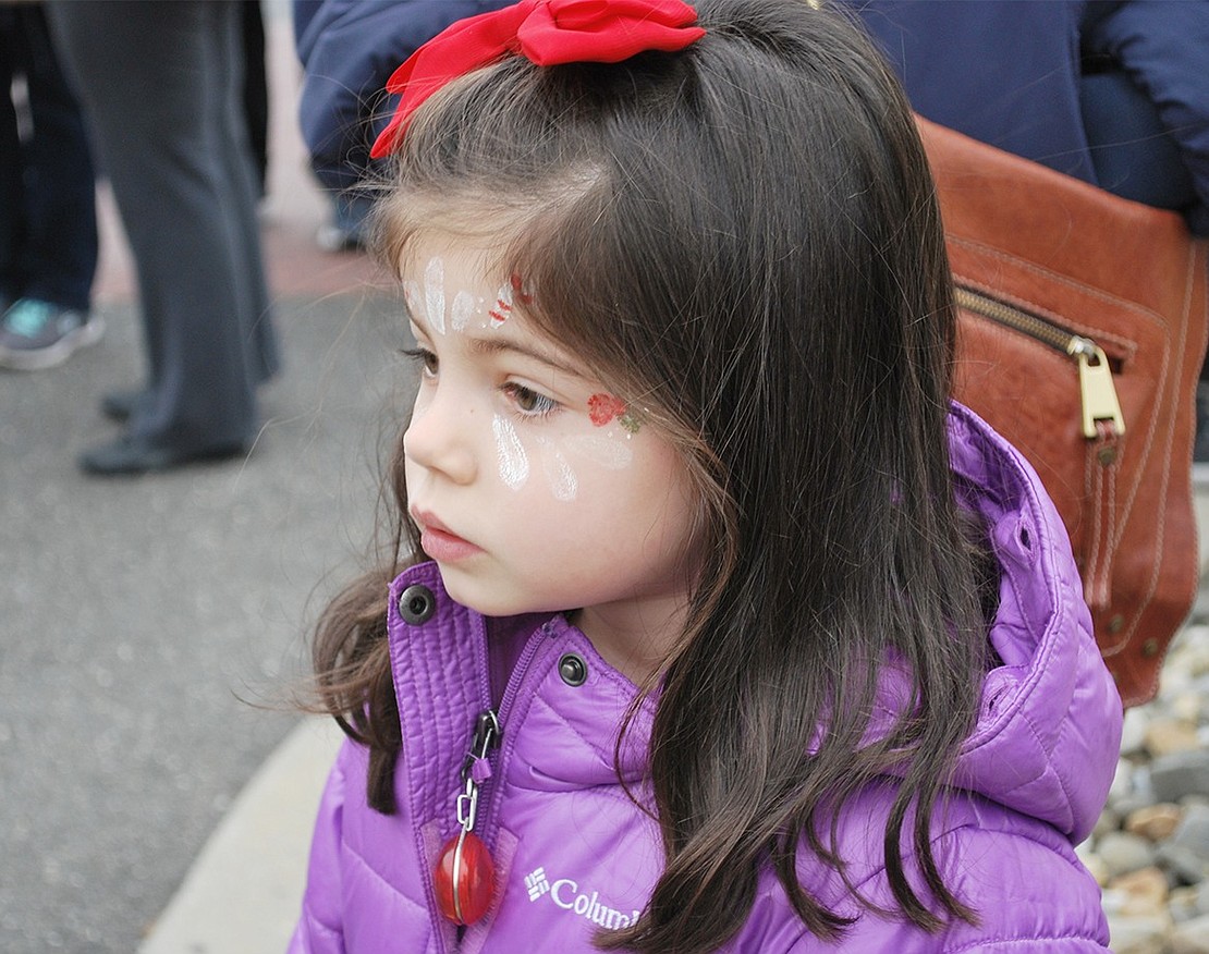 Five-year-old Jillian Gasparini of Rye Brook came to the show with candy cane and mistletoe face painting. She watches the marching drumline in awe, despite the cold