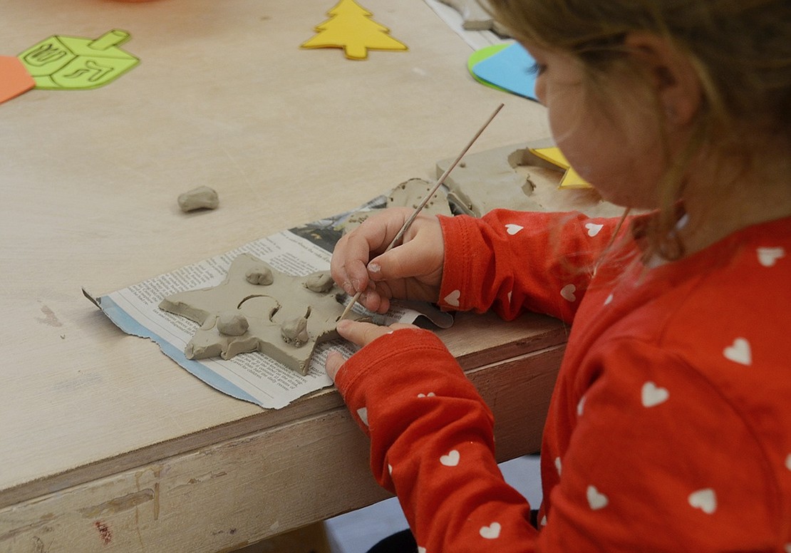 Larchmont 5-year-old Scarlett Siotkas adds some final touches to her star ornament before moving on to the painting phase. 