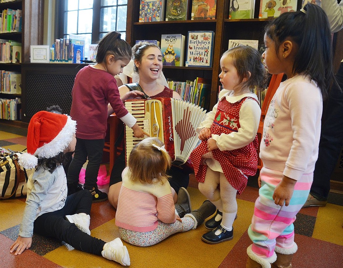 A group of toddlers surround Chloe to listen to her sing some jingles and get a closer look at her accordion at the Chloe’s Kids Presents: Sing-Alongs with Santa at the Port Chester-Rye Brook Public Library on Tuesday, Dec. 12.  