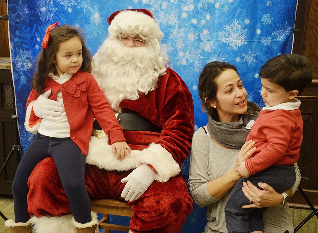 Michael Ferreira, a 2-year-old, is a little nervous about meeting Santa, but his 4-year-old sister, Sarah, and mother, Mara, help him gain the courage. “Silly Santa,” played by Ellis Adler, traveled by horse and sleigh from Long Island to meet the children.    