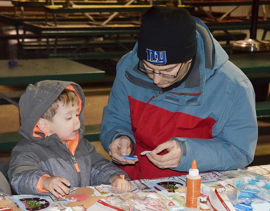 Rye Brook resident John Scutero helps his 2-year-old son, Anthony, make a gingerbread man at the arts-and-crafts table.