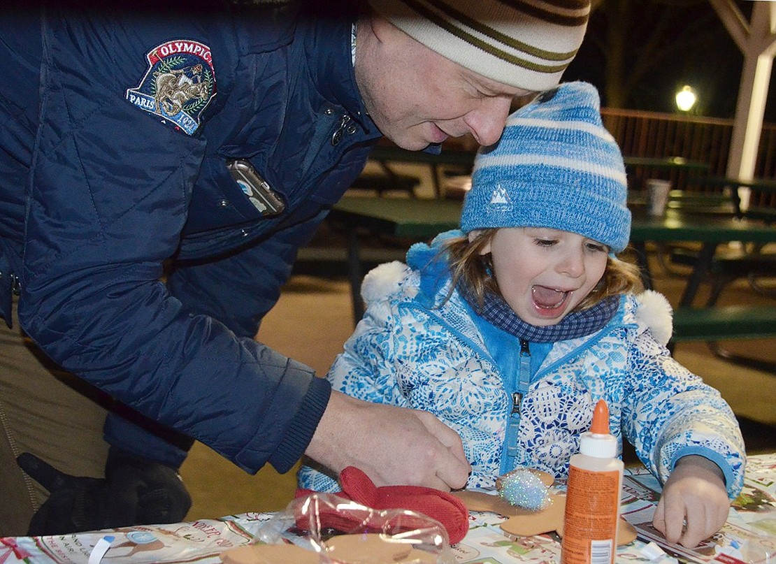 Munson Street 4-year-old Anneliese Klaschka is excited by her father Stephan’s, suggestions for her gingerbread man at the arts-and-crafts table.