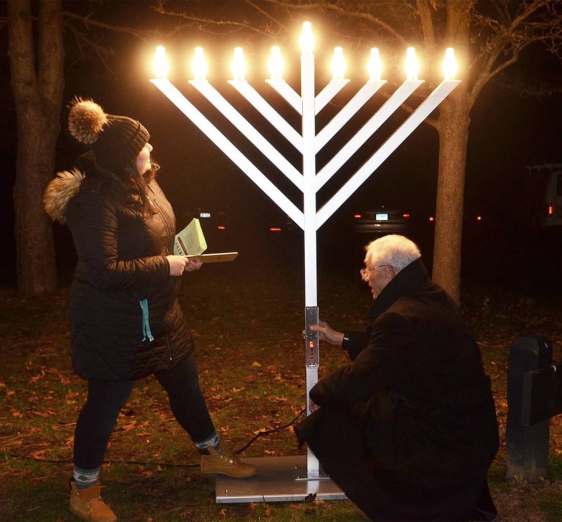 Town of Rye Supervisor Gary Zuckerman and Sara Summa, the clerk assistant who played a major role in organizing the festivities, light the menorah at during the Rye Town Holiday Lights Celebration and Concert at Crawford Park on Friday, Dec. 8. 