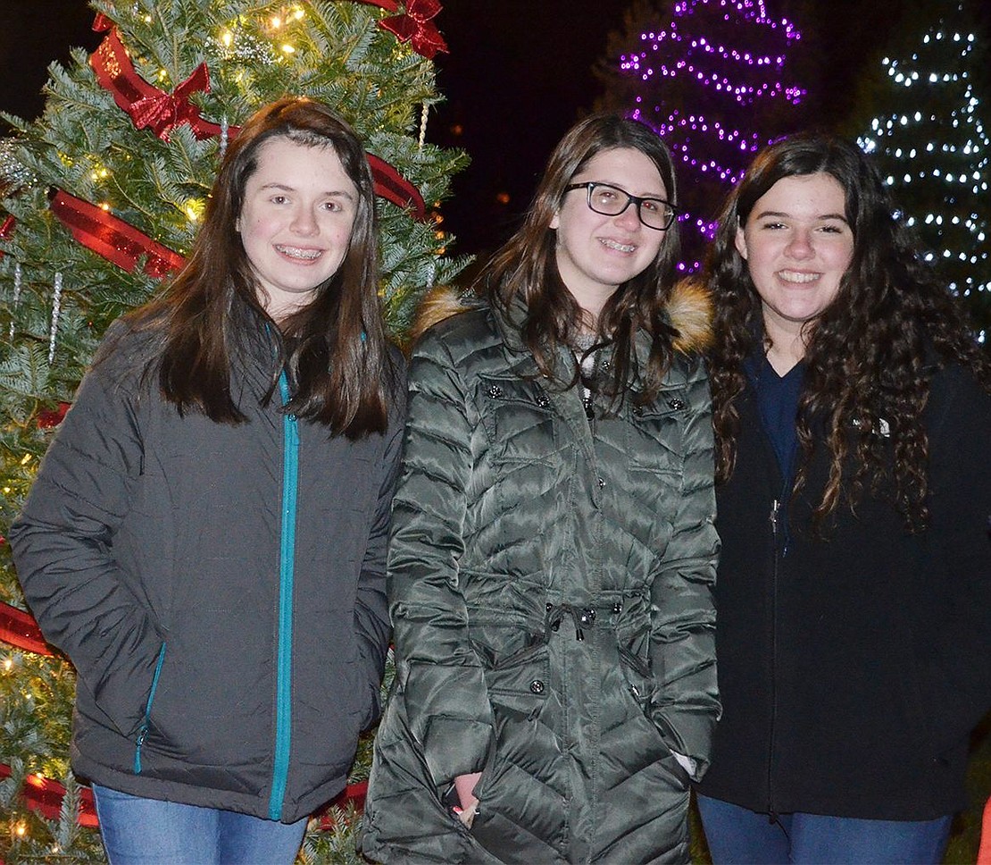 Port Chester High School 14-year-olds Molly McHugh (left), Casey Basso and Gianna Villanova admire the glowing Christmas trees at the park. 