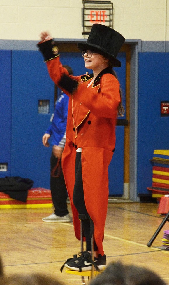 Ringmaster Tatum Korpi waves to the crowd while she introduces her classmates performing with stilts.