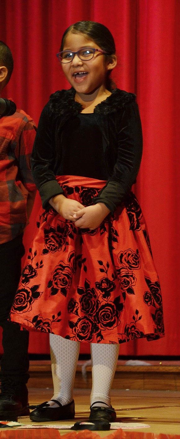 Carina Lopez, a first-grader, is happy to wear her classy holiday dress and perform for a full audience. 