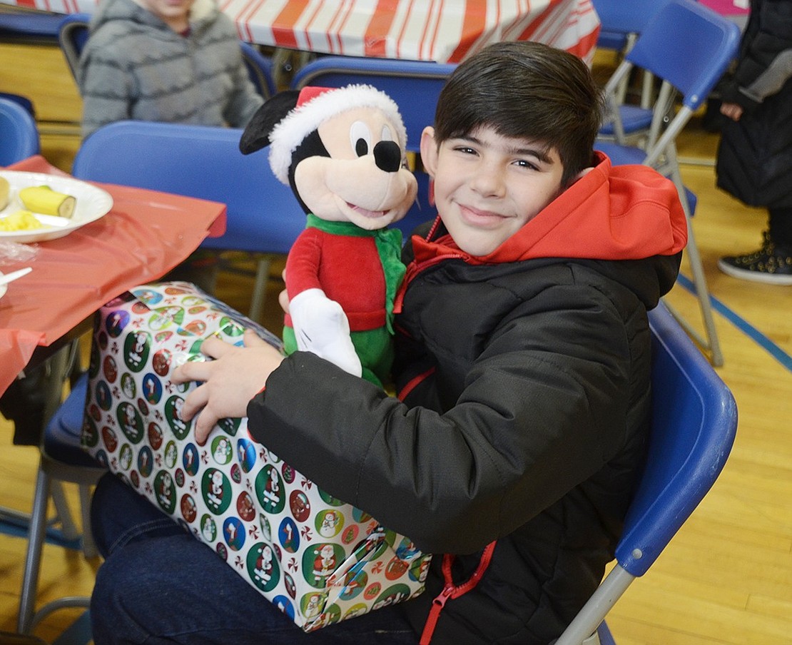 Francisco Reies, a 10-year-old student at Thomas A. Edison Elementary School, is definitely satisfied with his presents. All the children meeting Santa received a gift. According to Ann Heekin, executive director of the Don Bosco Center, the gifts were donated by local stores, churches and synagogues. 
