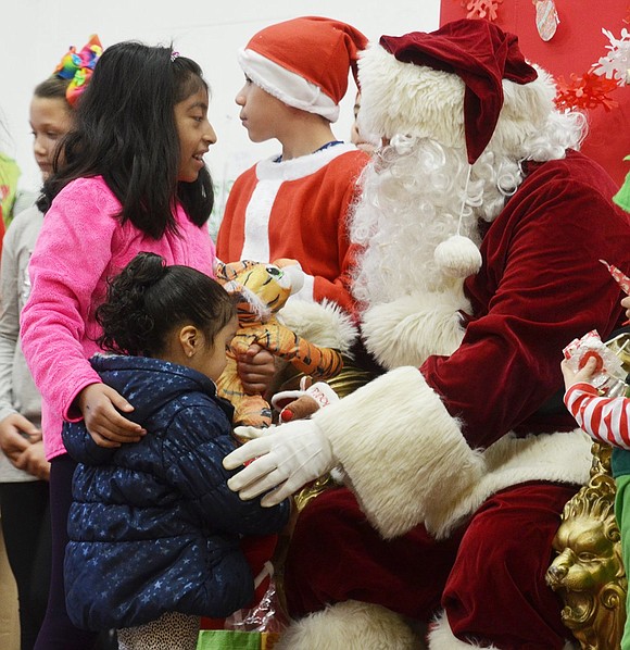 Santa, greets Ashley Ramirez, a 9-year-old Park Avenue Elementary School student, and her niece, 3-year-old Itziaxunelly Pedroza.  