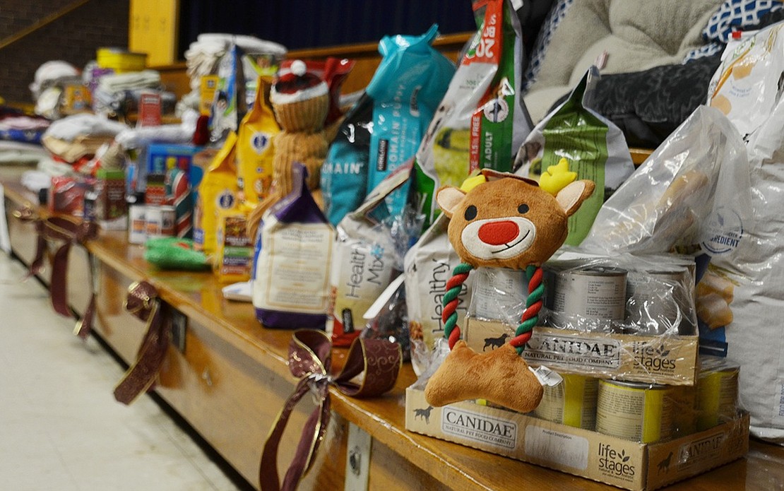 Food, treats, toys and pet supplies align across the auditorium stage before Pet Rescue puppies come in to relish their presents.