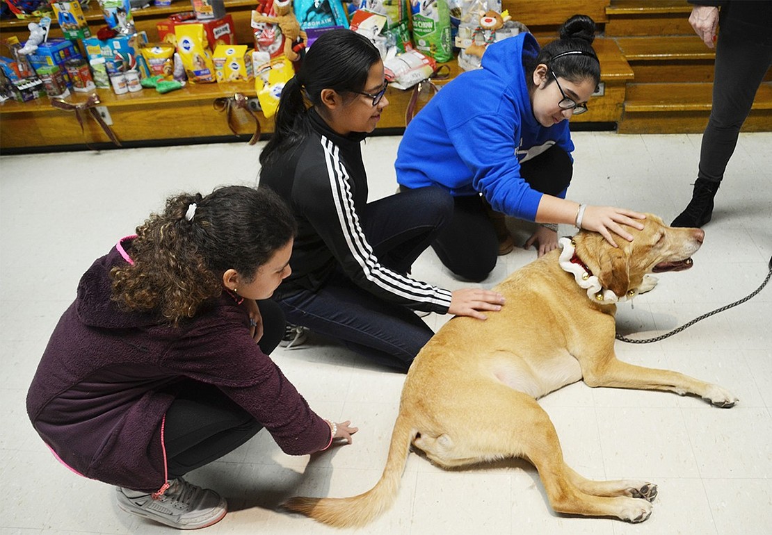 Five-year-old Archie is enjoying love from all angles by eighth-grade students Catherine Reyes (left), Judith Castillo and Natasha Marroquin. 