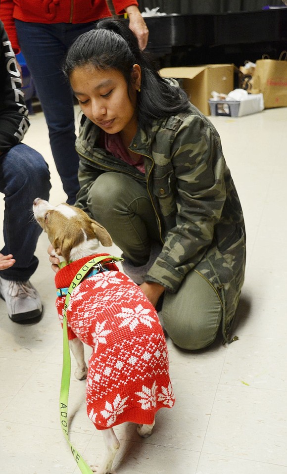 Eighth-grader Jenny Guam gives some gentle love to a dog rescued from West Virginia. 