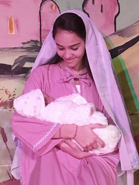 Mary, played by Gabriela Silva, caresses baby Jesus, played by Santiago Morocho, during Corpus Christi-Holy Rosary School’s play “The Christmas Chronicle” on Wednesday, Dec. 20 in the school’s gymnasium. Courtesy of Kathleen Zaccagnino 