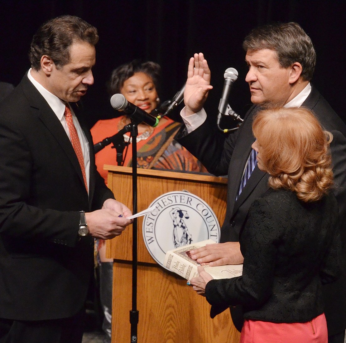 Governor Andrew Cuomo swears in George Latimer to his first four-year term as Westchester County Executive as Latimer’s wife Robin holds the Bible during his inauguration ceremony at Westchester Community College on Sunday, Jan. 7. The auditorium was filled, and many people were forced to watch from an overflow classroom.