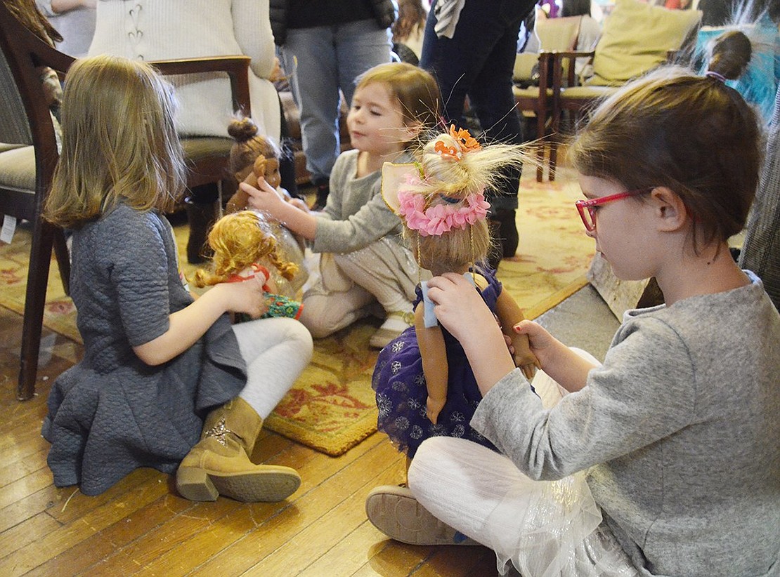 Five-year-old Ava Winchenbach (left) plays with sisters Zoe and Kristen March (right) and their dolls on the floor at the Girl Scout House. 