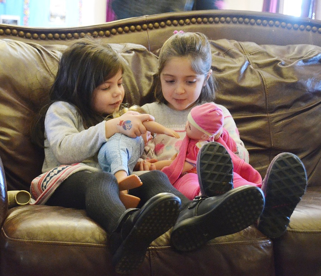 Ridge Street School five-year-old Jillian Gasparini (left) gets cozy with her Glenville, Ct. friend Isabella Galizi, also 5, on the couch while they play with baby dolls. 
