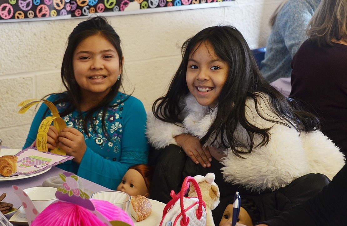 Brianna Conda helps Lyndsay Arroyo, both 9-year-old Park Avenue School students, keep track of her raffle tickets.