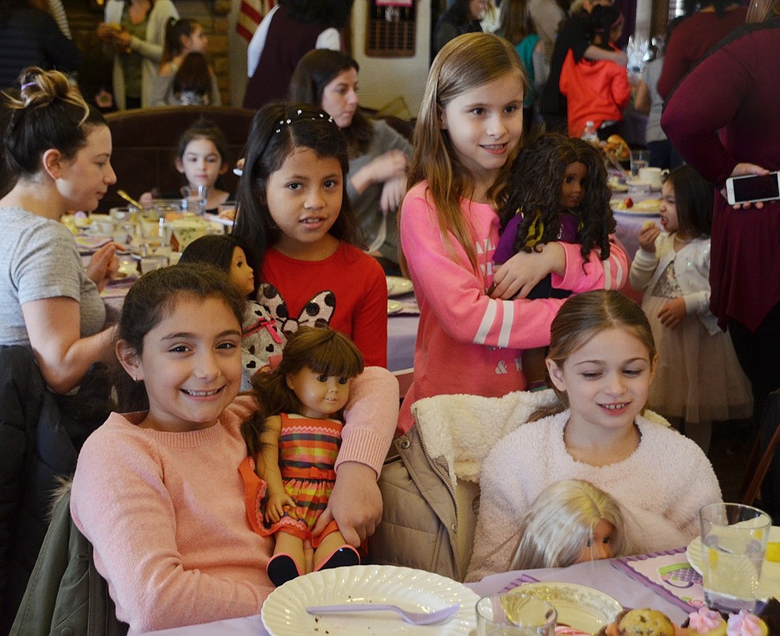 Julianna Trinidad (top left), a Park Avenue School 8-year-old, Lauren Hempel, Marisa Rachiele (bottom left) and Gianna Rende, all King Street School 8-year-olds, mingle with their dolls and munch on treats. 