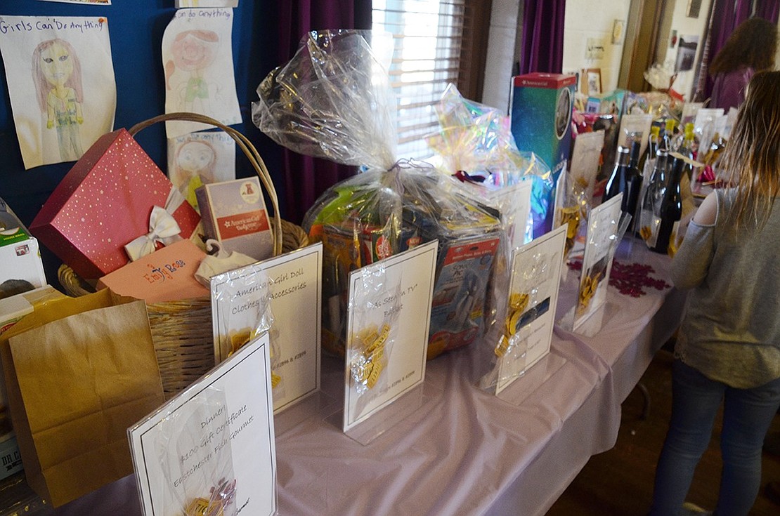 An array of gift baskets and gift certificates donated by local businesses line the wall in a Chinese auction for participants to choose which ones they want to take a chance on.