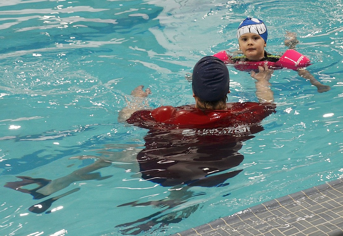 Emma Ruiz doggy-paddles to her mother, Karen, in the Carver Center’s newly renovated pool during the winter program exhibition at the Carver Center at 400 Westchester Ave. on Wednesday, Jan. 17. Guests toured the center in maze fashion to visit students and employees describing different programs. 