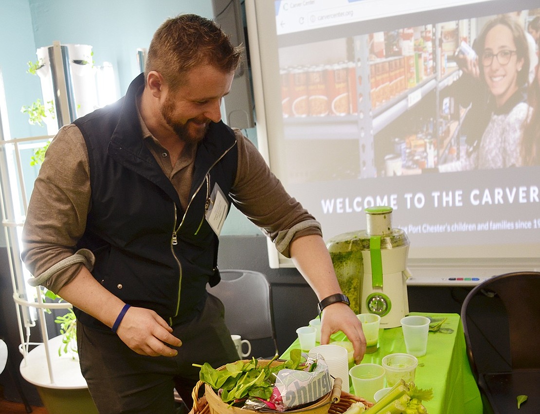 Carver Center CEO Joseph Kwasniewski juices together apples and ginger into a healthy drink in the Carver Market, a food pantry that serves more than 400 people every month. 