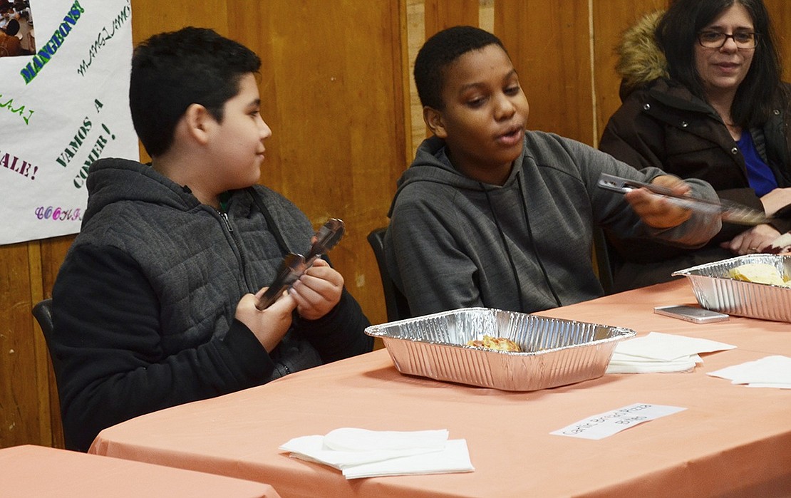 Yisneuri Jimenez (right), 12, and Anthony Enriquez, 11, pass out quesadillas they made in the Cooking Club for guests starting their tour.