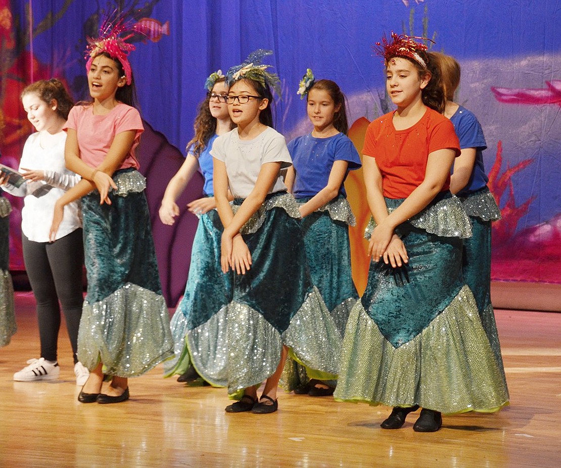 Triton’s princesses perform a song and dance routine about their little sister Ariel’s new love-struck state.