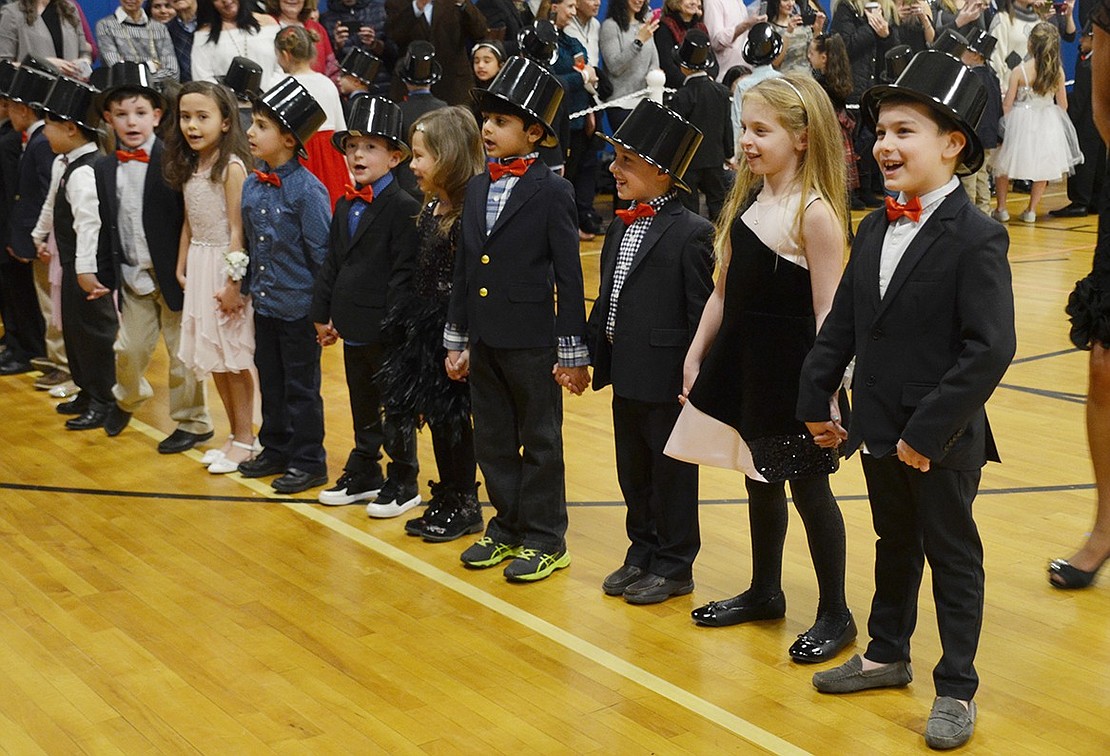 A group of first-graders cheerily serenades their parents with “I Am Your Child” by Barry Manilow.