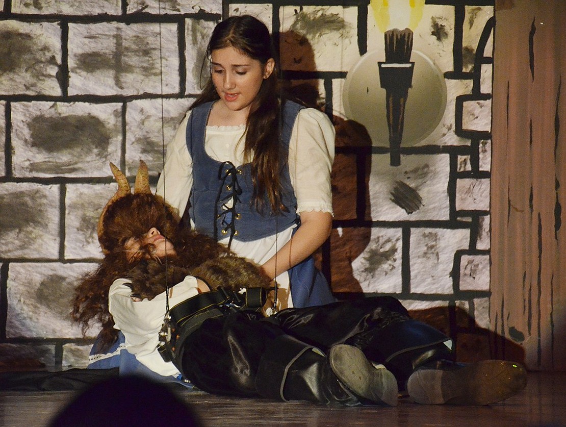 Belle, played by Gwen Dominguez, cares for the Beast, played by Michael Perrone, who’s near-death after being attacked by Gaston. 