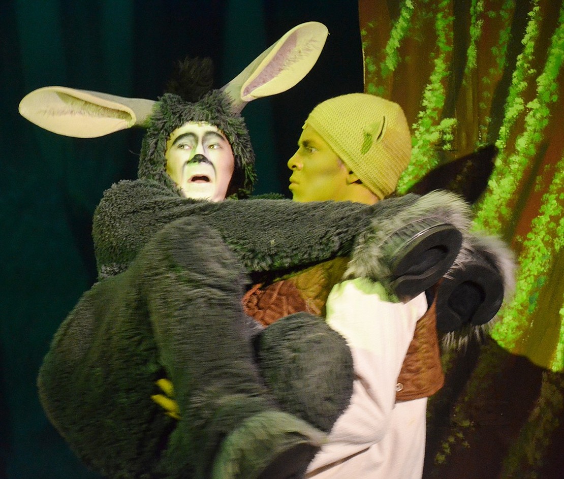 Scared by passing trouble, Donkey (played by Justin Levine) jumps into Shrek’s (played by Michael Lieberman) arms. 