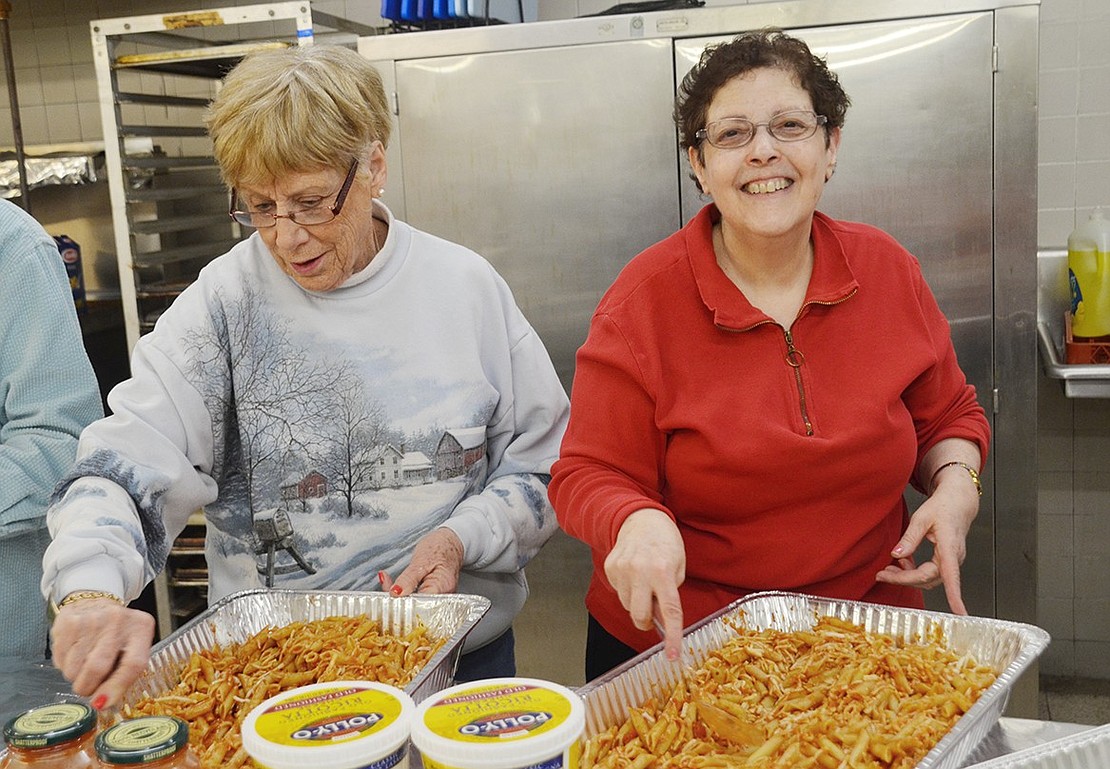  Allene Berman of Rye Brook (left) and Helene Simon of Port Chester prepare four giant trays of baked ziti to donate to St. Peter’s Soup Kitchen in Port Chester. 