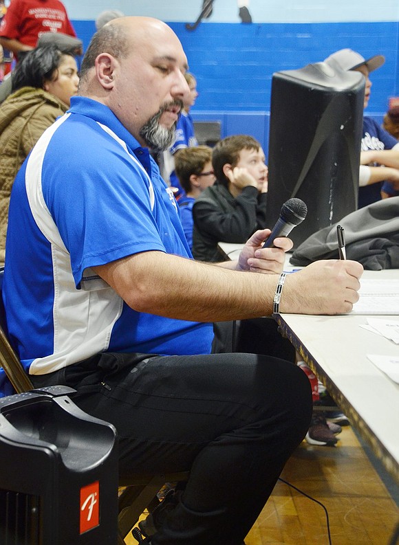 Announcer for the night and booster club member Joe Rinello tallies up the scores.