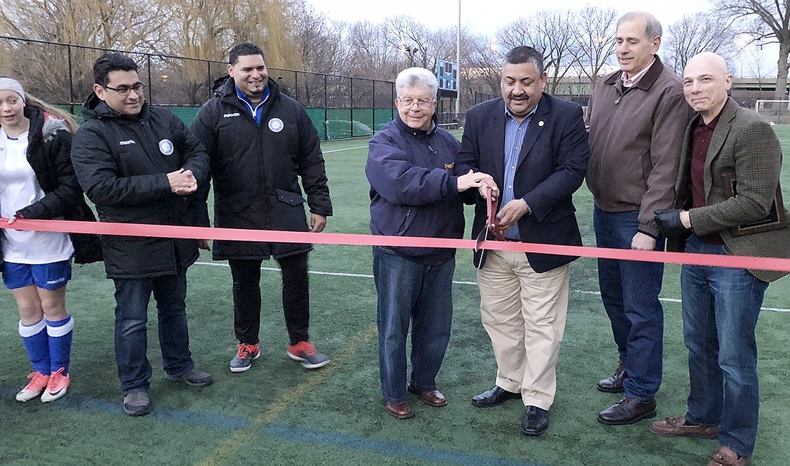 Trustee Luis Marino and Mayor Richard “Fritz” Falanka cut the ribbon held by two female soccer players to mark the first official use of the lights at the Columbus Park soccer field on Thursday, Mar. 15. They are accompanied by, from left, Port Chester Soccer Club Treasurer David Hidalgo, Port Chester Soccer Club Acting President Aaron Guerrero, Trustee Gene Ceccarelli and Trustee Frank Ferrara. Once the ribbon was cut, everyone yelled: “Let there be light!” Recreation Supervisor Heather Krakowski flipped the switch and two teams of girls played the first game under the lights. Courtesy of Janusz Richards 