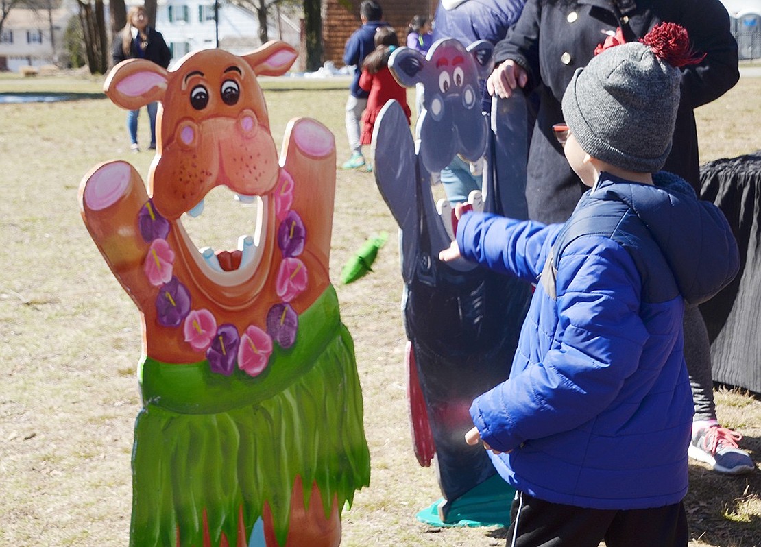 Practicing good aim, 5-year-old JFK Elementary School student Justin Tintaya tosses a beanbag into a festive and hungry looking hippo’s mouth. 