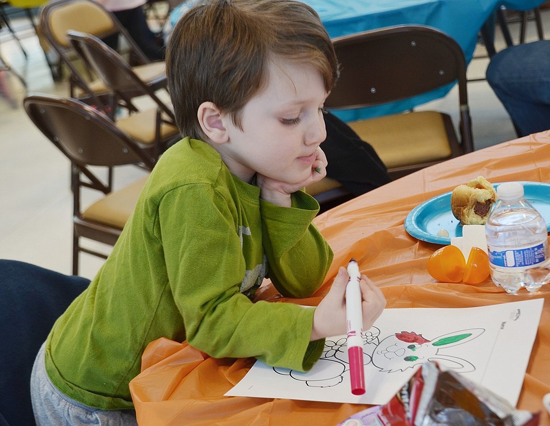 Four-year-old Elliot Klein carefully considers how much pink to use in his Easter Bunny drawing. 