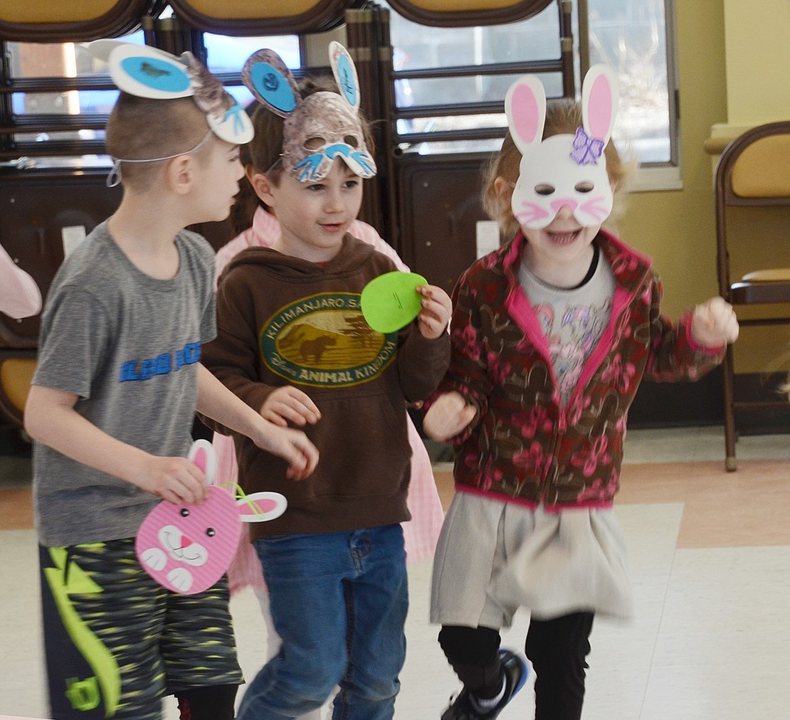 While waiting for the entertainment to arrive, 6-year-old Meadowlark Road resident Jonah Bergtraum (left), 5-year-old Windingwood Road North resident Blake Sager and 5-year-old Mackenzie Vinopoll get ready to race across the floor in their Easter Bunny masks.