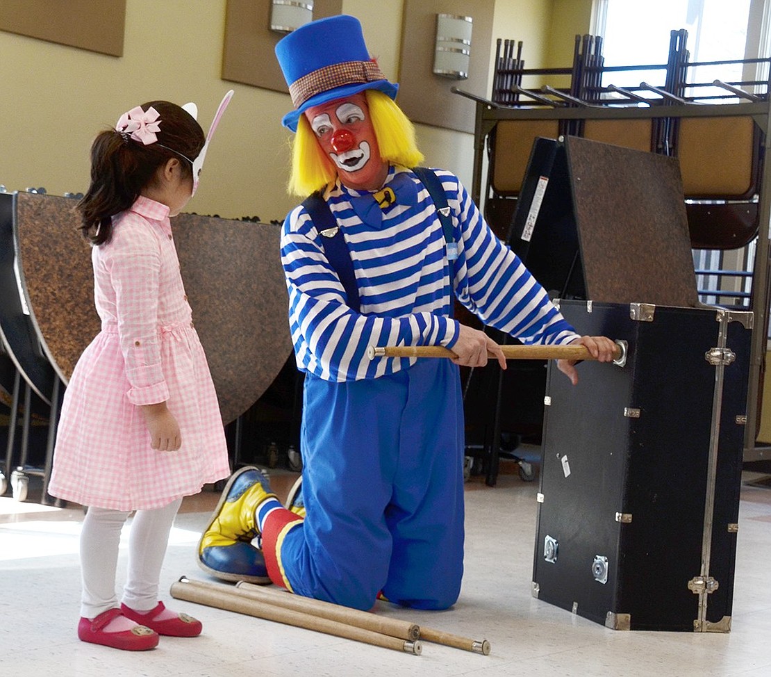 As Macaroni the Clown sets up his act, 4-year-old Avon Circle resident Amelia Zuccarelli looks a little skeptical of his tactics. 